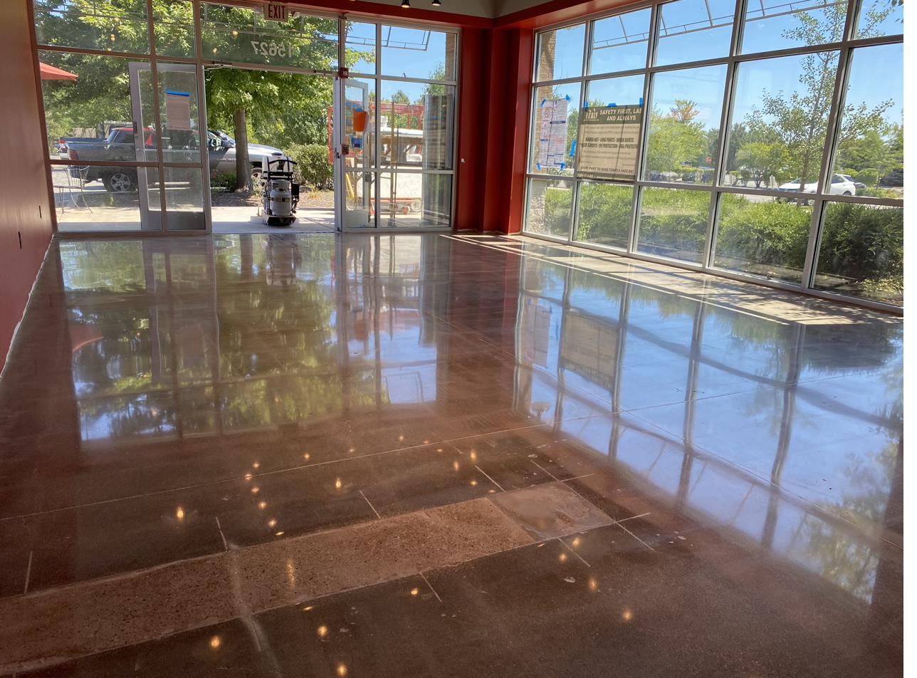 Concrete polishing machine grinding a retail store floor mid project